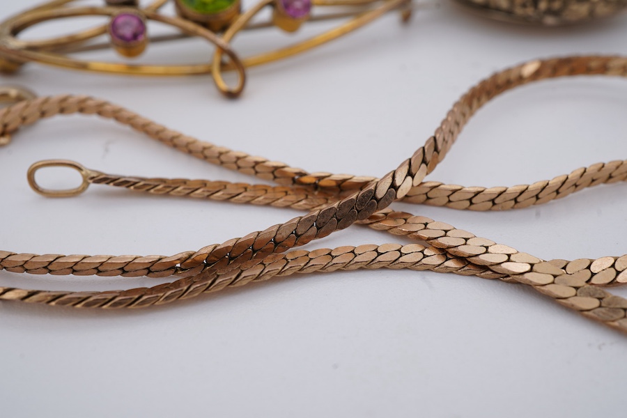 A group of jewels, comprising, a 9ct gold flat curb chain, length 37.5cm, British hallmarks, gross weight 5 grams; a gilt metal locket pendant; an Edwardian gilt metal, green and pink paste brooch; and a silver brooch se